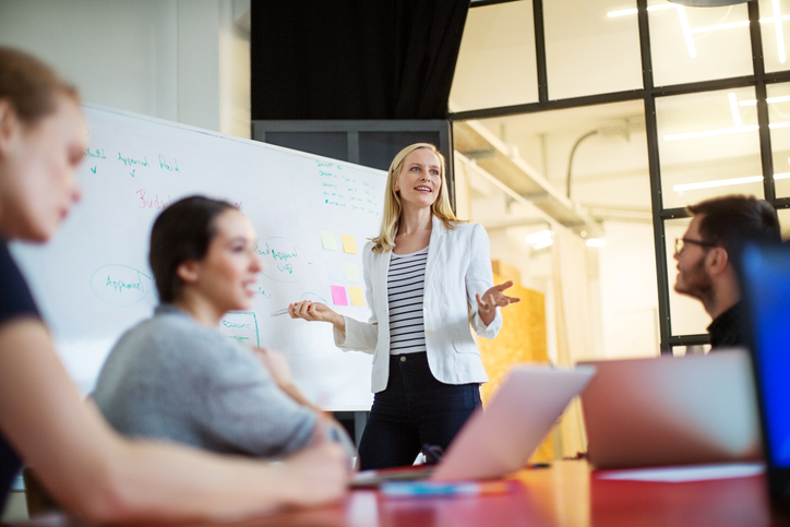 people in a meeting with a whiteboard